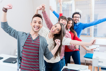 Gruppe Studenten voll Freude in Universität, haben die Prüfung bestanden