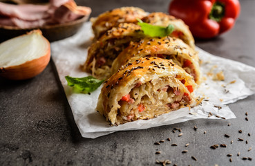 Savory strudel stuffed with sour cabbage, bacon, red pepper and onion - obrazy, fototapety, plakaty