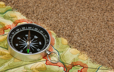 Naklejka na ściany i meble compass on the map with sand