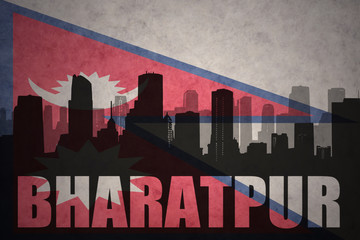 abstract silhouette of the city with text Bharatpur at the vintage nepal flag background