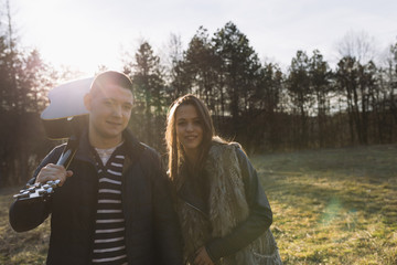 Beautiful teenager couple hugging and kissing. They enjoy autumn nature outdoors. Warm sunlight, flare and strong back light.