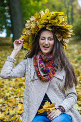 smiling, happy girl wearing a wreath of maple leaves