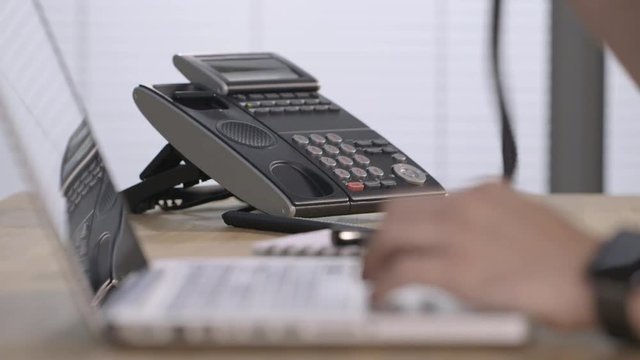 Male hands typing and answering a phone