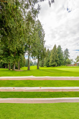 Fototapeta na wymiar Golf course with wooden fence