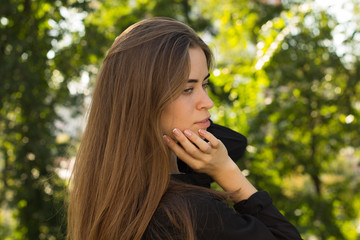 Young woman standing back on the background of trees