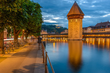 Night view towards Chapel Bridge (Kapellbruecke) together with the octagonal tall tower (Wasserturm) it is one of the Lucerne's most famous tourists attraction
