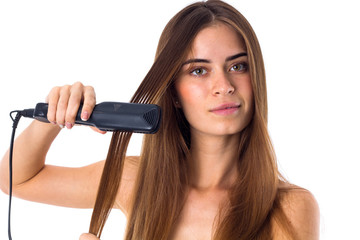 Woman using hair straightener 