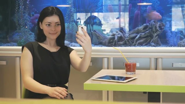 Brunette girl making selfie photo using smartphone