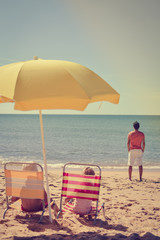 Joyful family having fun on beach sunny outdoors background. Back view
