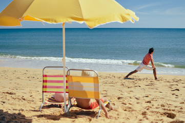 Joyful family having fun on beach sunny outdoors background. Back view