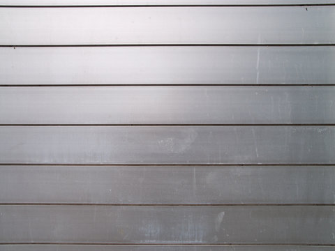 Wall made of metal plates, a little dirty and weathered, useful as background