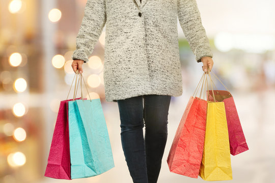 Woman with shopping bags on blurred market background. Christmas shopping concept.
