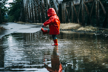 .Boy splashing in puddle
