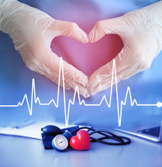 Heart beat line and doctor hands in gloves making heart shape. Cardiology and health care concept.