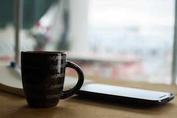Close up of  a cup of coffee and mobile phone
