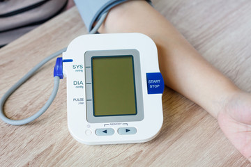 Woman using digital blood pressure monitor