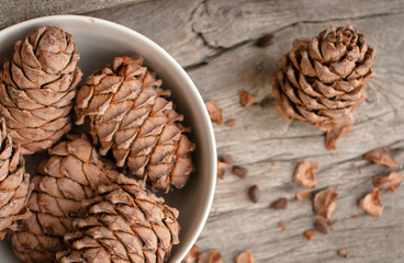 Pine cone and nuts on wood.