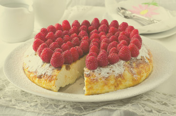 Cheesecake, souffle, cream mousse, pudding dessert with fresh raspberries and mint leaves on a white plate