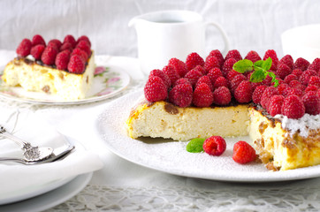 Cheesecake, souffle, cream mousse, pudding dessert with fresh raspberries and mint leaves on a white plate