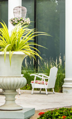 Relaxing space in cozy garden./ White chair and flower pot on relaxing space in cozy garden on summer.
