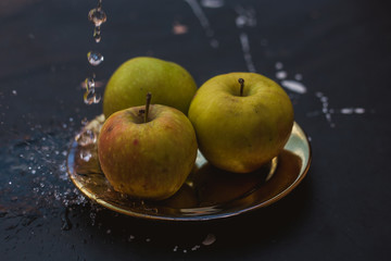 apples in the water stream standing on the plate outdoors