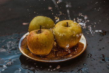 apples in the water stream standing on the plate outdoors