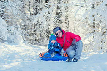 Fototapeta na wymiar Happy Toddler boy with dad in the snowy forest