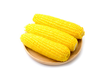 Tasty boiled corn on wooden plate white background 