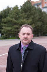 Portrait of a serious man with a mustache in a business suit 