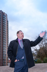 Man in suit shows a hand toward  