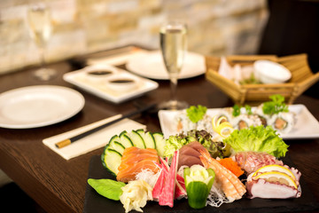 Dish of sashimi and rolls with wine in restaurant
