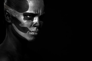 Halloween. Woman in day of the dead mask skull face art. Halloween face art on black background. Halloween make up
