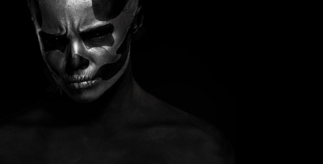Halloween. Woman in day of the dead mask skull face art. Halloween face art on black background. Halloween make up
