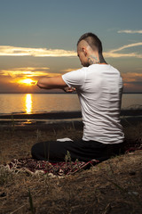 Young flexible man in meditation lotus pose