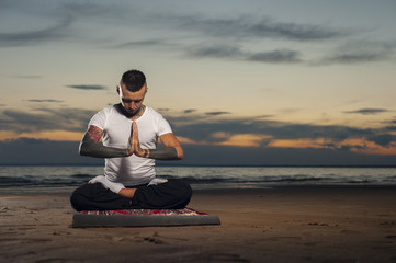Fototapeta premium Yoga practice outdoors: man sitting in lotus pose