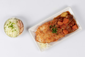 Deep fried dolly fish (Crispy) in Japanese style topped yellow curry with side dish as sliced cabbage and pickled ginger are very delicious