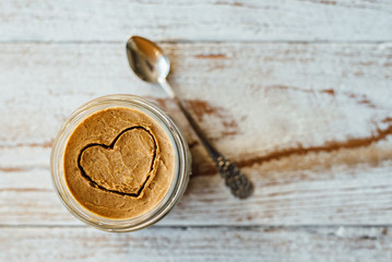 Heart drawn on peanut butter in glass jar