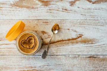 Heart drawn on peanut butter in glass jar