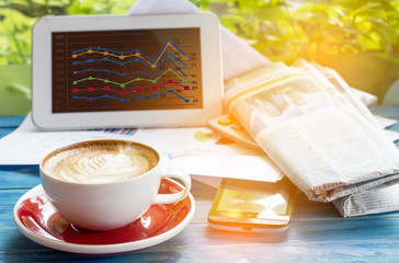 concept image of served Latte art coffee during checked summary graph in paper and mobile phone