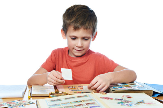 Boy with his collection of old postage stamps isolated