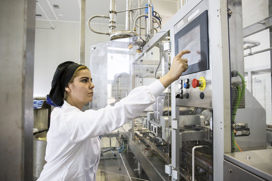 Woman operating a machine during the making of chocolate in a factory