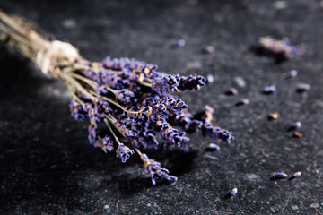 Ein Strauß getrockneter Lavendel auf einer schwarzen Steinplatte