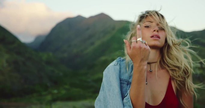 Beautiful carefree young woman giving the middle finger, fashion lifestyle