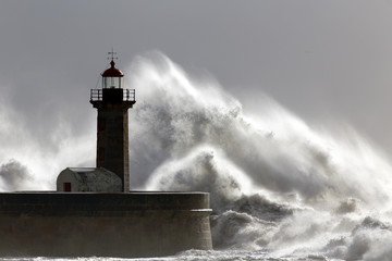 Big stormy waves over old lighthouse
