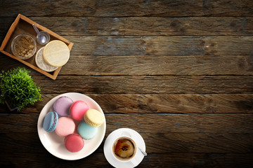 cup of coffee and colorful macaroons on wood Background. View from above.