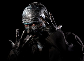 Studio portrait of a man in monster makeup, dark background