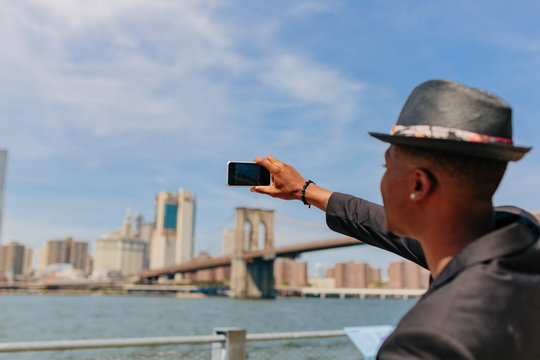 Young Fashionable Guy Taking Picture of the Manhattan Skyline . New York City