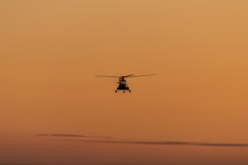 Fototapeta na wymiar Silhouette of helicopter with sunset sky