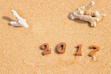 Fototapeta na wymiar Wood number 2017 on beach, happy new year concept and tropical beach idea