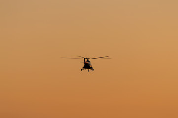 Silhouette of helicopter with sunset sky